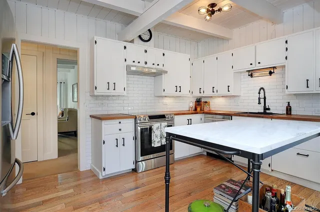a kitchen with stainless steel appliances a stove refrigerator sink and cabinets