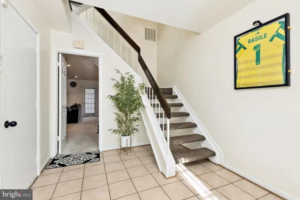 a view of a hallway with stairs and wooden floor