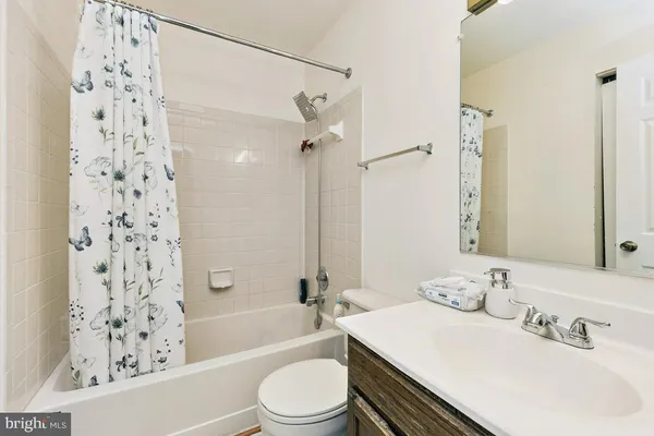 a bathroom with a sink a toilet a mirror a bathtub and shower
