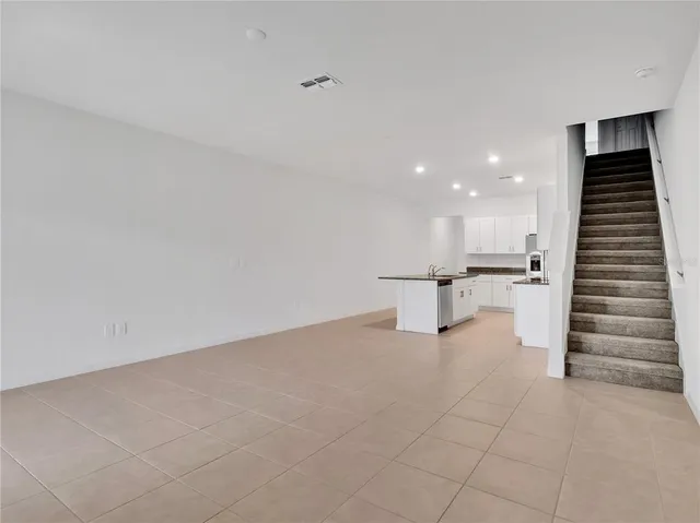 a view of an empty room with a kitchen