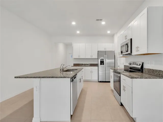 a kitchen with stainless steel appliances granite countertop a sink and cabinets