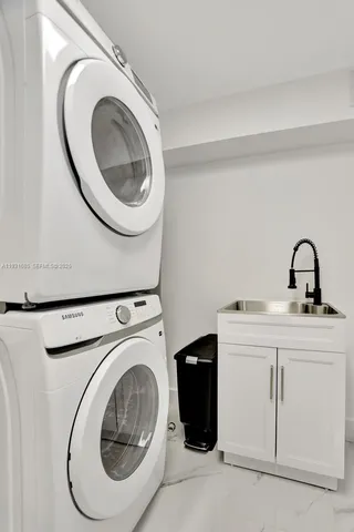 a utility room with sink dryer and washer