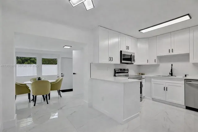 a kitchen with a sink and chairs