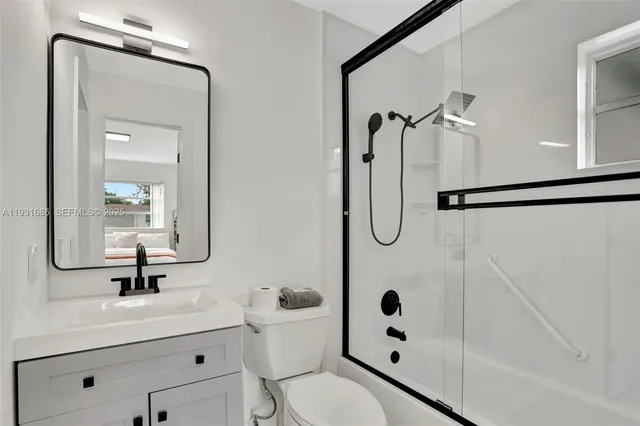 a bathroom with a sink a toilet and a mirror