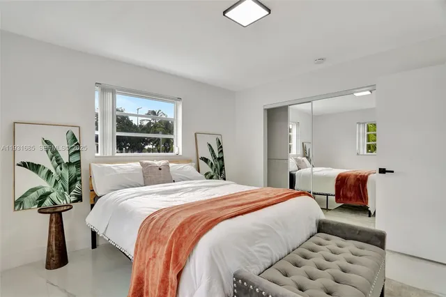 a bedroom with bed and a painting on the wall