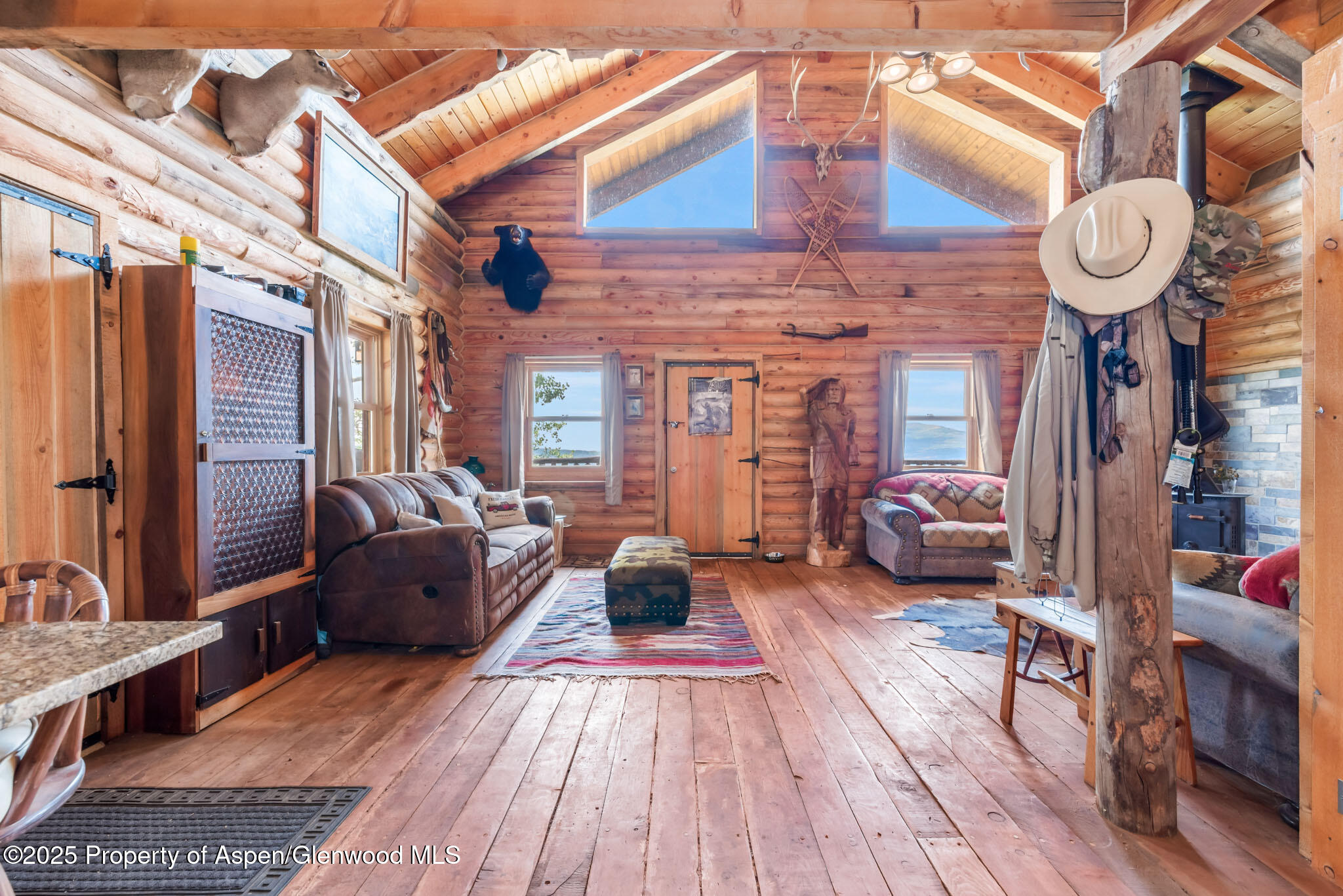 943 Routt Forest Drive Craig, CO 81625 - Photo 14 of 120 a living room with furniture a fireplace and a chandelier