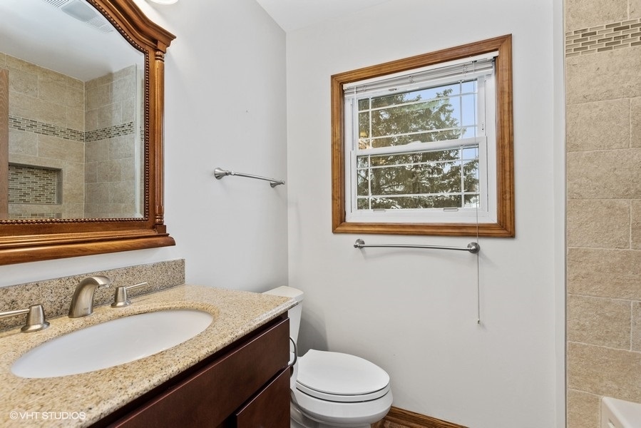 1310 Chatsworth Lane Hoffman Estates, IL 60169 - Photo 11 of 18 a bathroom with a granite countertop sink toilet a mirror and shower