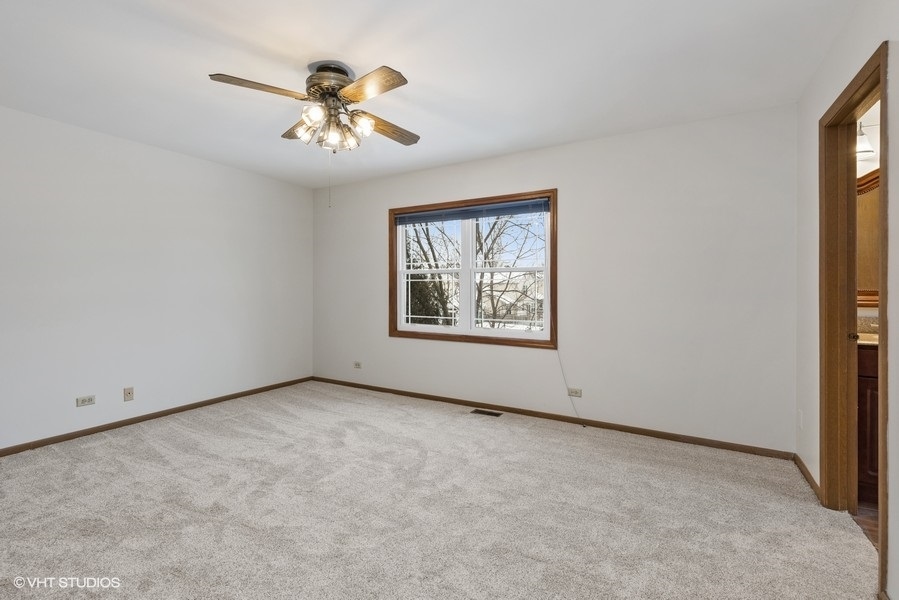 1310 Chatsworth Lane Hoffman Estates, IL 60169 - Photo 10 of 18 an empty room with windows and chandelier fan