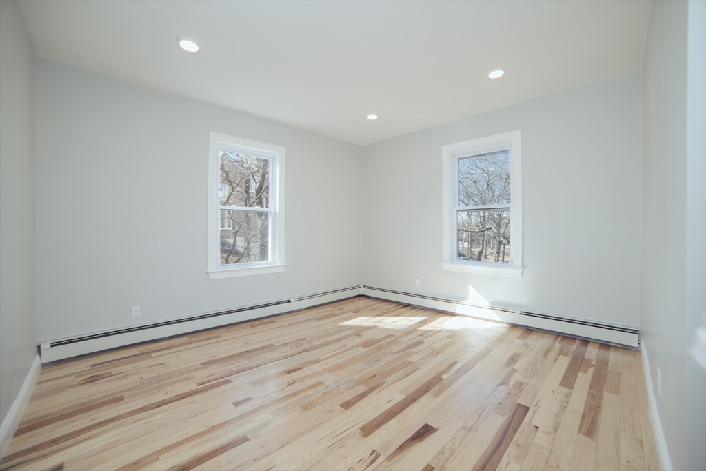 10 Duffley Court, Unit 1 Brookline, MA 02467 - Photo 13 of 23 wooden floor in an empty room with a window