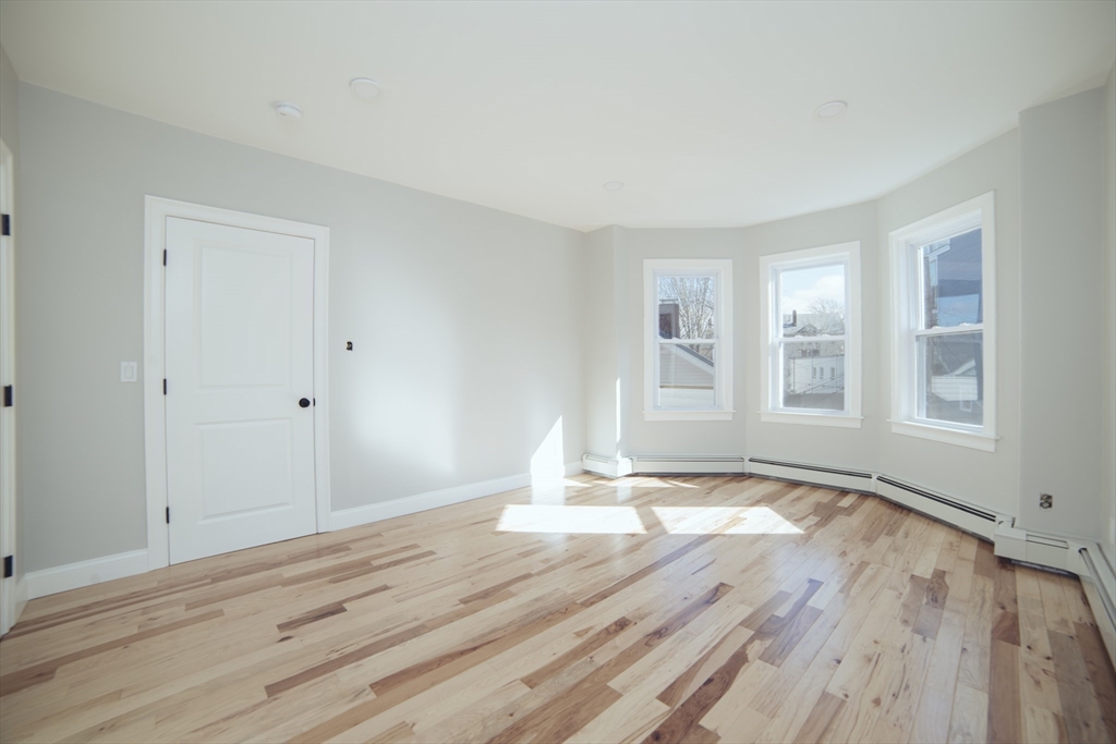 10 Duffley Court, Unit 1 Brookline, MA 02467 - Photo 16 of 23 a view of empty room with wooden floor and fan