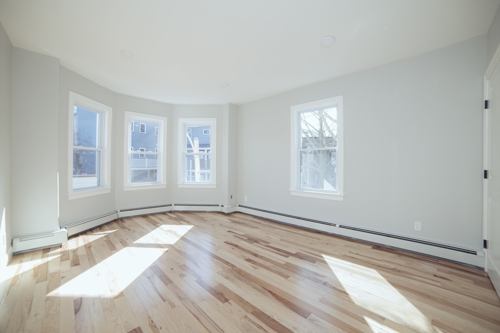 10 Duffley Court, Unit 1 Brookline, MA 02467 - Photo 18 of 23 a view of an empty room with wooden floor and a window