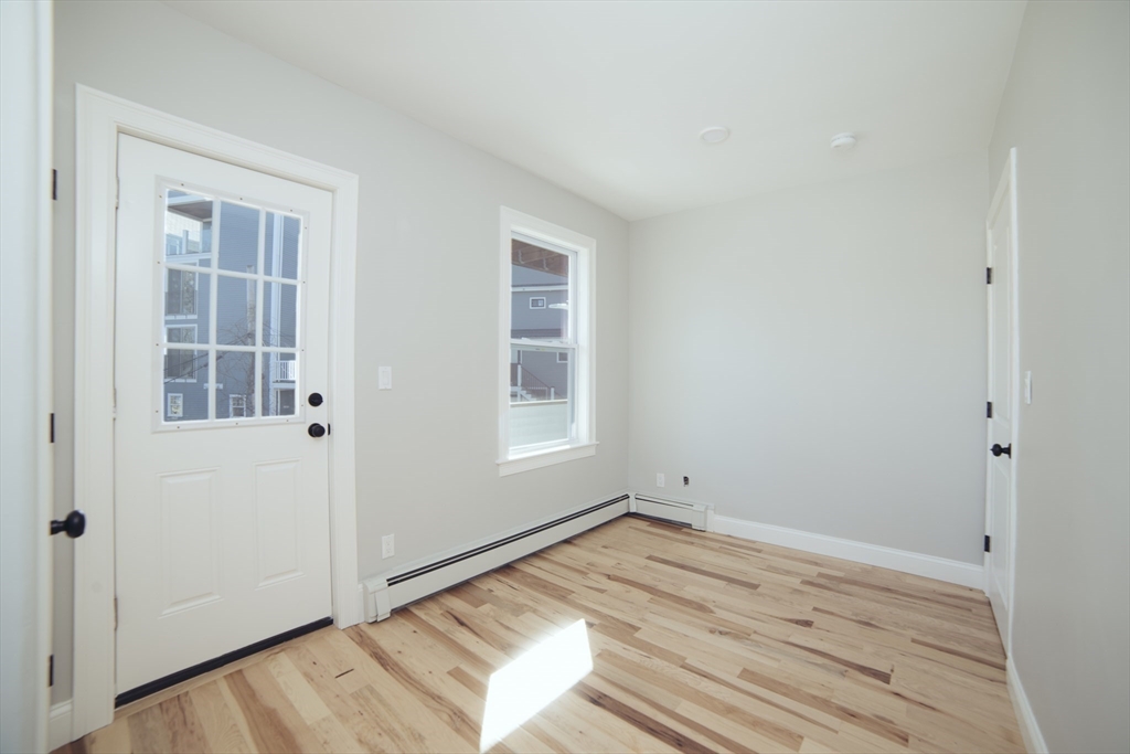 10 Duffley Court, Unit 1 Brookline, MA 02467 - Photo 19 of 23 an empty room with wooden floor and windows