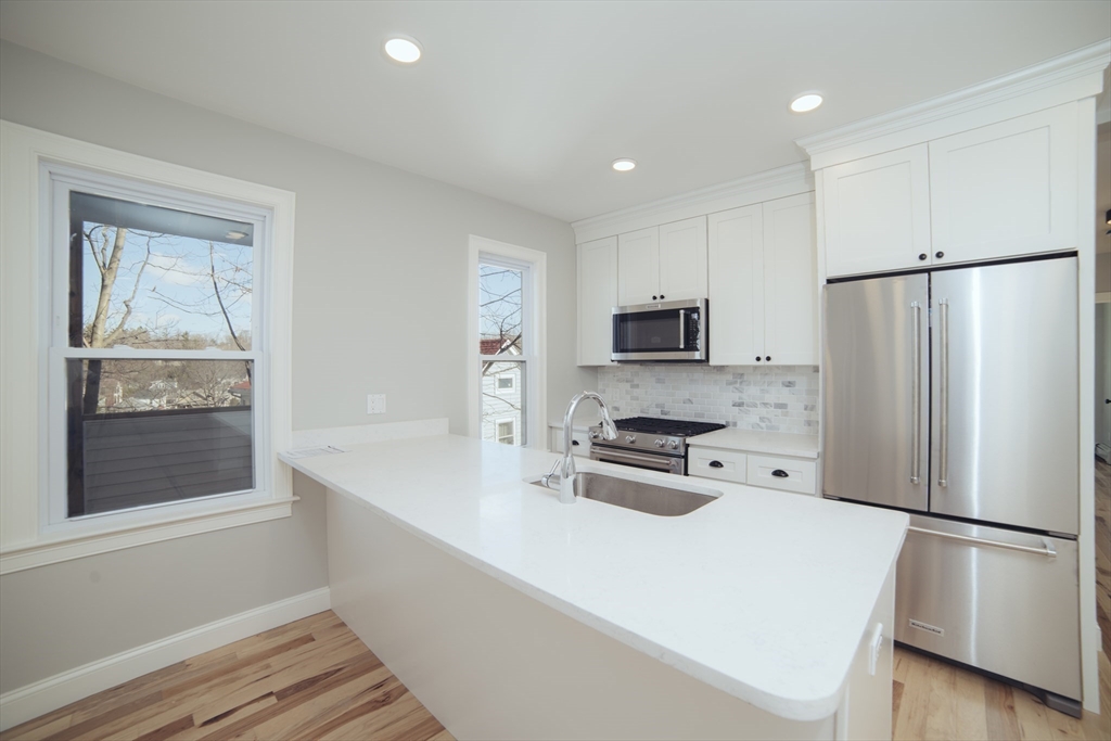 10 Duffley Court, Unit 1 Brookline, MA 02467 - Photo 4 of 23 a kitchen with stainless steel appliances a refrigerator sink and microwave