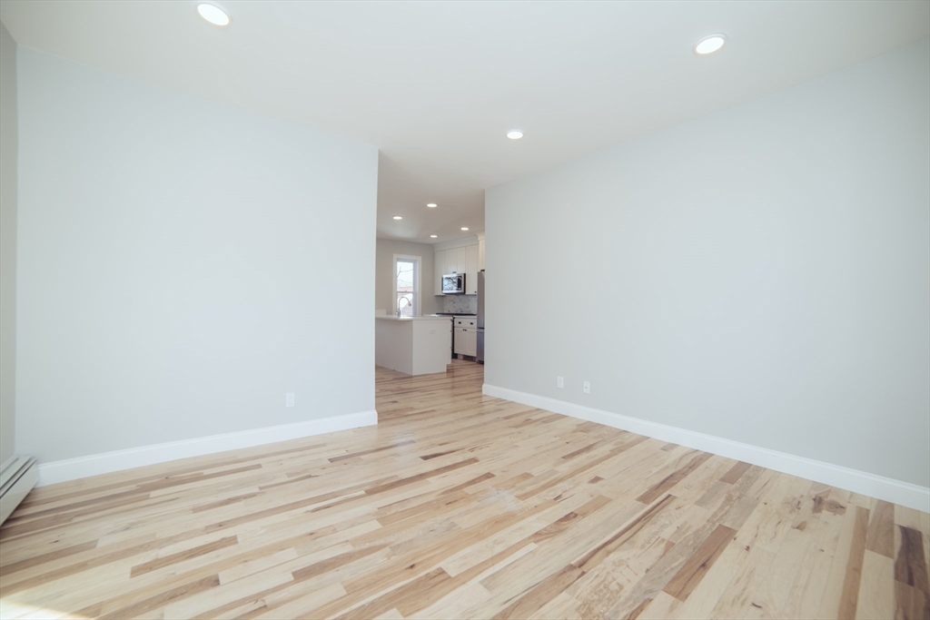 10 Duffley Court, Unit 1 Brookline, MA 02467 - Photo 7 of 23 a view of empty room with wooden floor