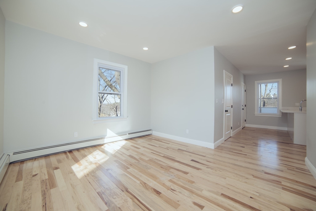 10 Duffley Court, Unit 1 Brookline, MA 02467 - Photo 8 of 23 wooden floor in an empty room with a window