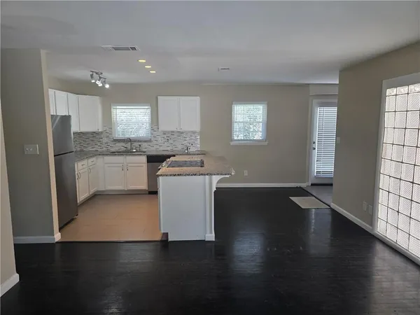 a kitchen with stainless steel appliances granite countertop a stove a sink and a microwave