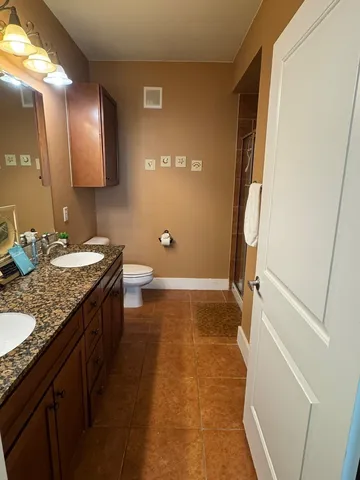 a bathroom with a granite countertop sink toilet and shower