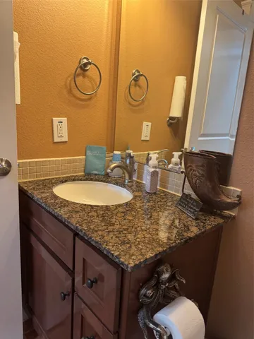 a bathroom with a granite countertop sink and a mirror