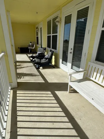 a view of a balcony with chair and wooden floor