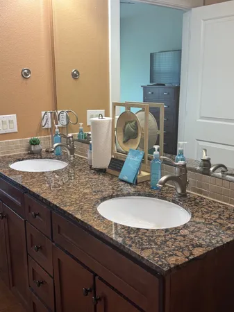 a bathroom with a granite countertop sink and a mirror