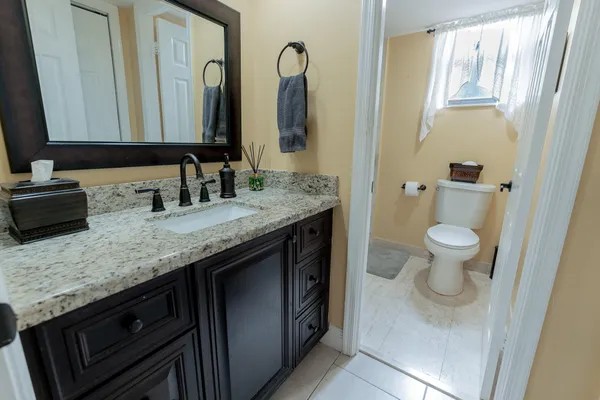 a bathroom with a granite countertop sink and a mirror