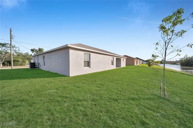 a view of a backyard with plants and large trees