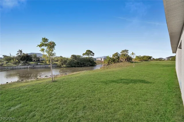 an aerial view of a house with a yard and lake view