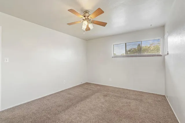 an empty room with wall painting and a ceiling fan