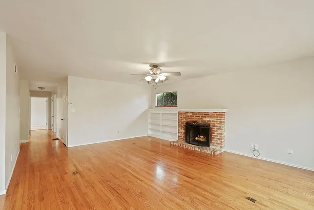 wooden floor fireplace and windows in an empty room