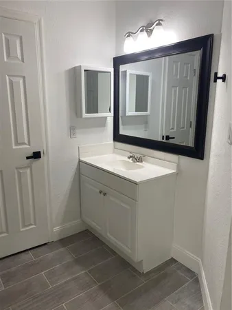 a bathroom with a sink vanity and mirror
