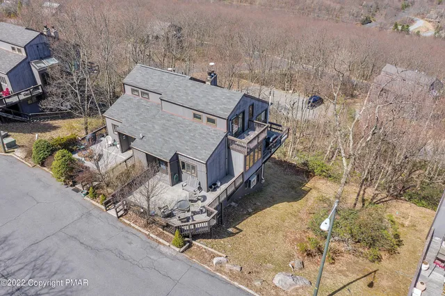 an aerial view of a house with large trees