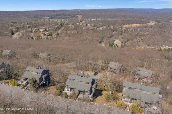 an aerial view of a house with a mountain