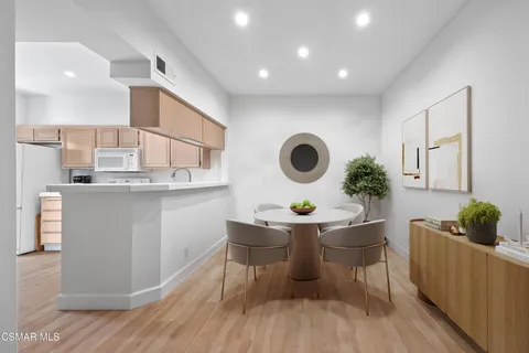 a kitchen with a sink and a stove with wooden floors