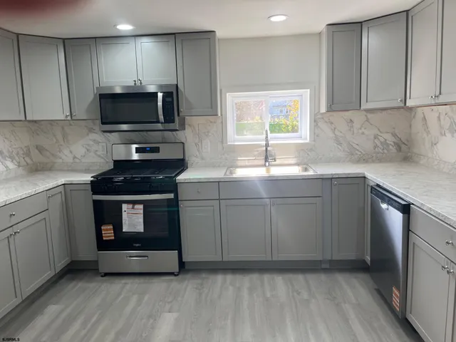 a kitchen with sink a microwave and cabinets