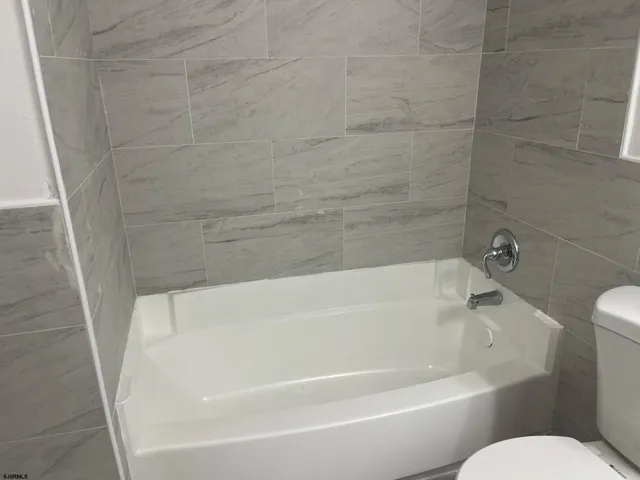 a white bath tub sitting next to a white toilet