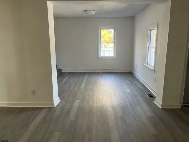 an empty room with wooden floor and a window
