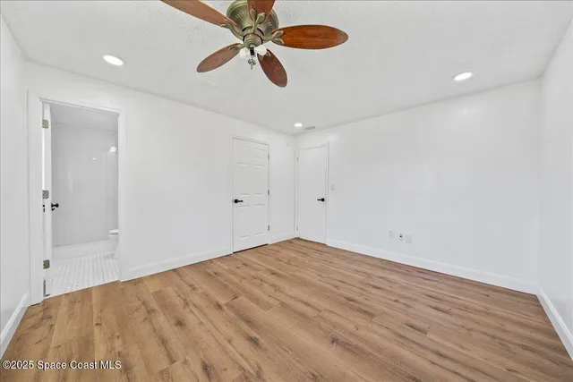 an empty room with fan and windows