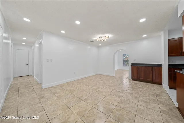 a view of a big room with a projector screen and windows