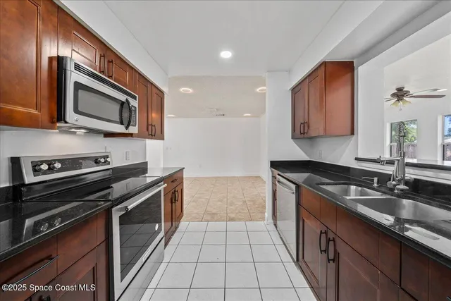 a kitchen with stainless steel appliances granite countertop a sink stove and microwave
