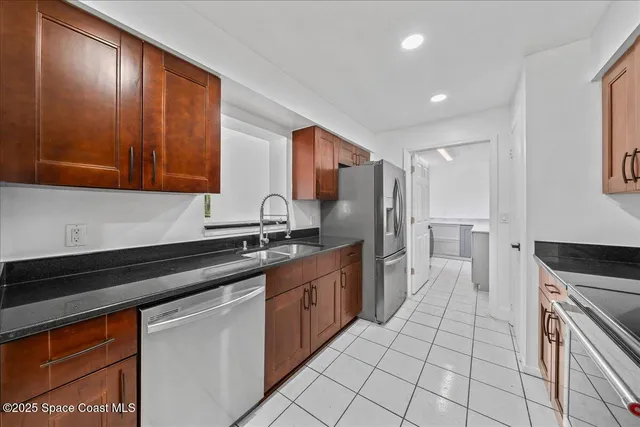 a kitchen with stainless steel appliances granite countertop a sink stove and refrigerator