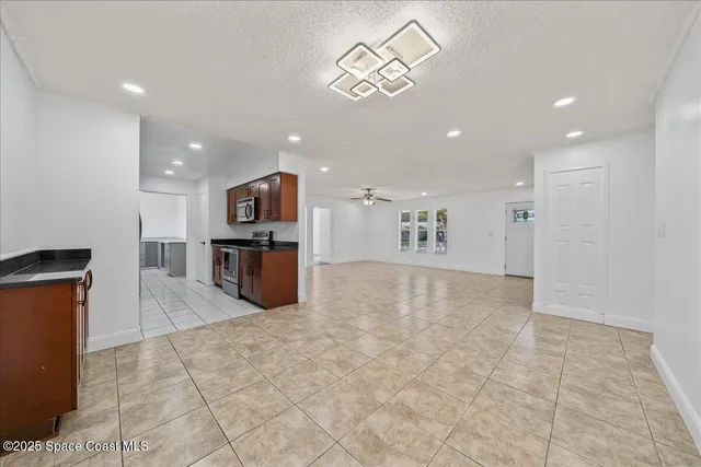 a view of kitchen with stainless steel appliances granite countertop a refrigerator and a sink