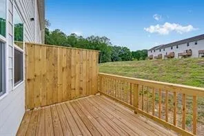 a view of a balcony with wooden floor and fence