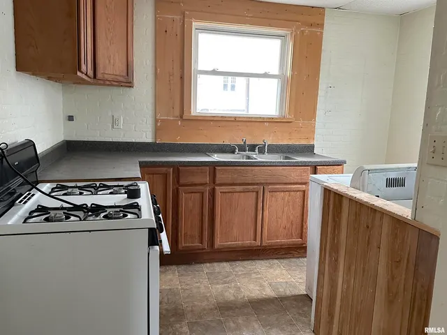 a kitchen with granite countertop cabinets stainless steel appliances and a sink