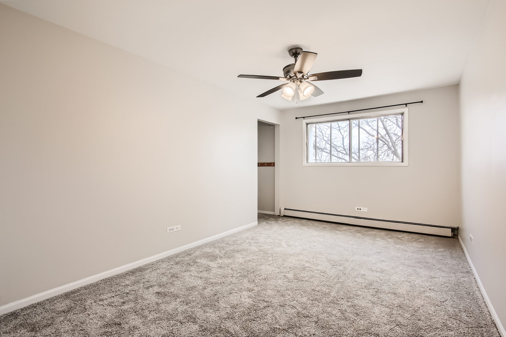 10430 Ridgeland Avenue, Unit 12 Chicago Ridge, IL 60415 - Photo 7 of 11 an empty room with windows and fan