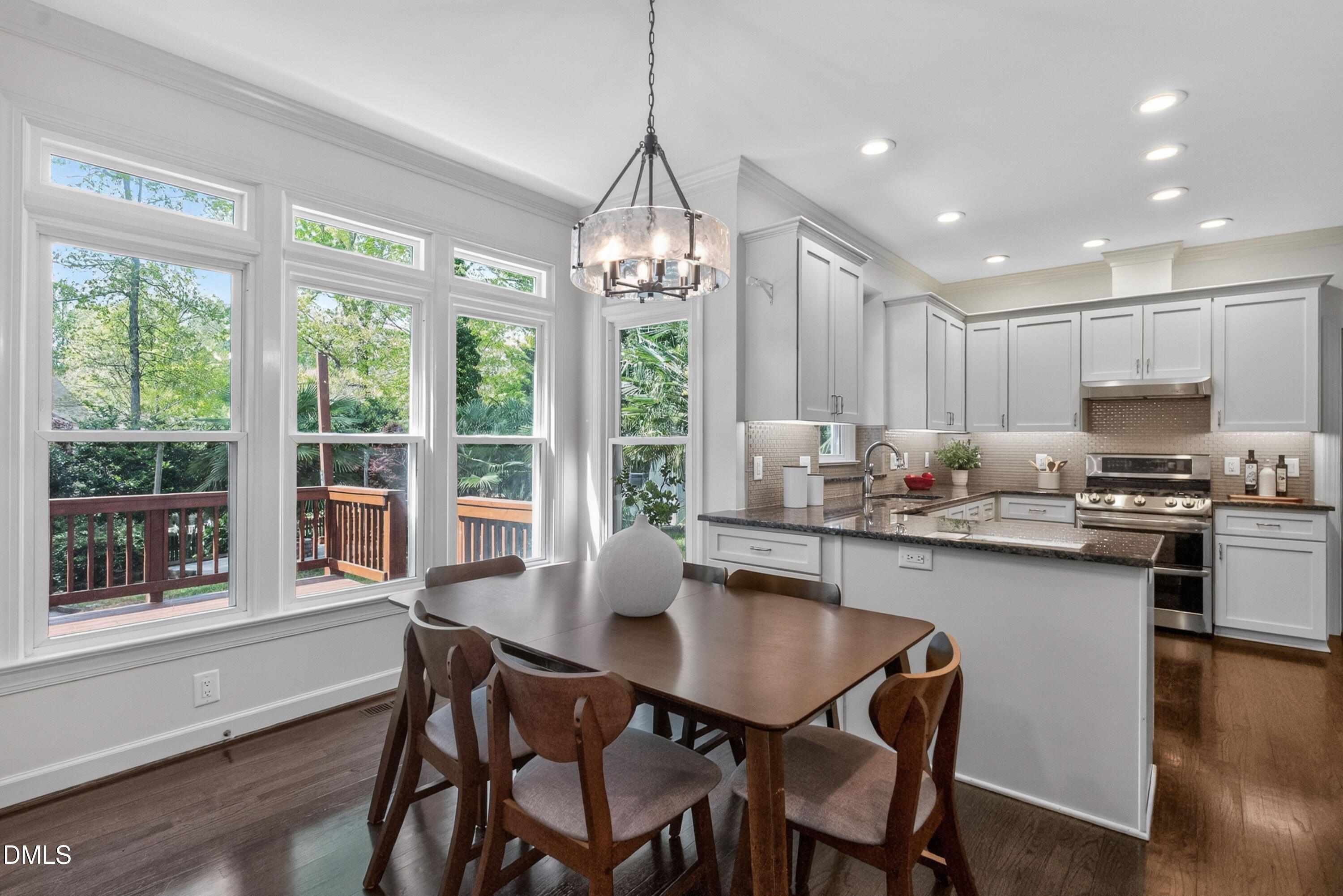 4021 Westwood Place Raleigh, NC 27613 - Photo 10 of 37 a kitchen with kitchen island granite countertop a dining table chairs and wooden floor