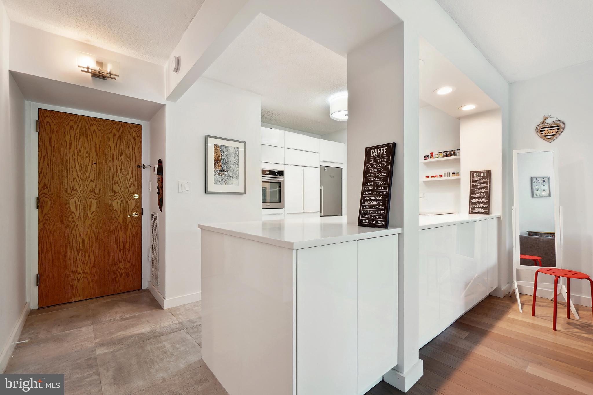 2141 Wisconsin Avenue Northwest, Unit 103 Washington, DC 20007 - Photo 12 of 30 a hallway with white cabinets and refrigerator