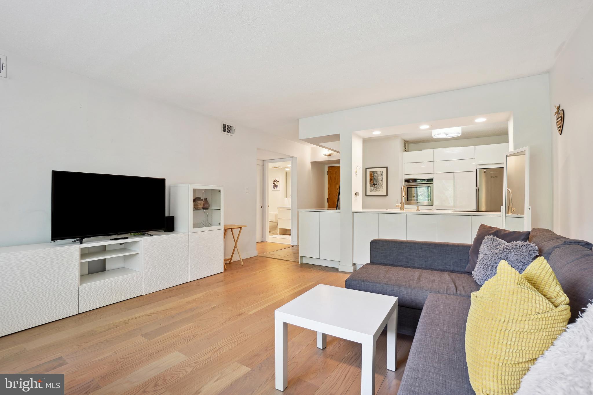 2141 Wisconsin Avenue Northwest, Unit 103 Washington, DC 20007 - Photo 19 of 30 a living room with furniture and a flat screen tv
