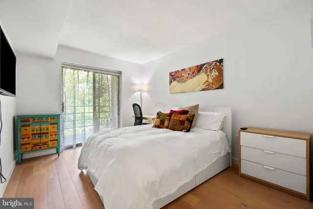 a large bed sitting in a bedroom next to a window