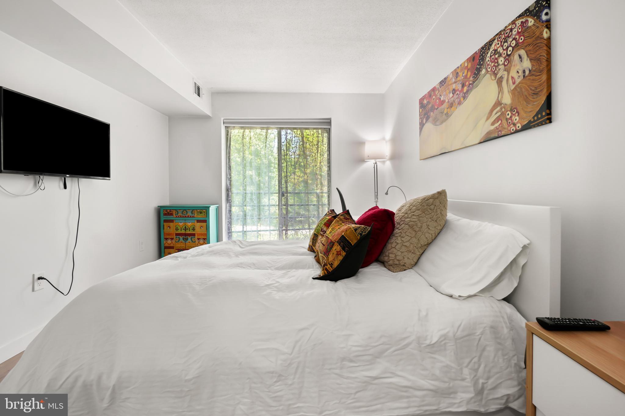 2141 Wisconsin Avenue Northwest, Unit 103 Washington, DC 20007 - Photo 23 of 30 a large bed sitting in a bedroom next to a window