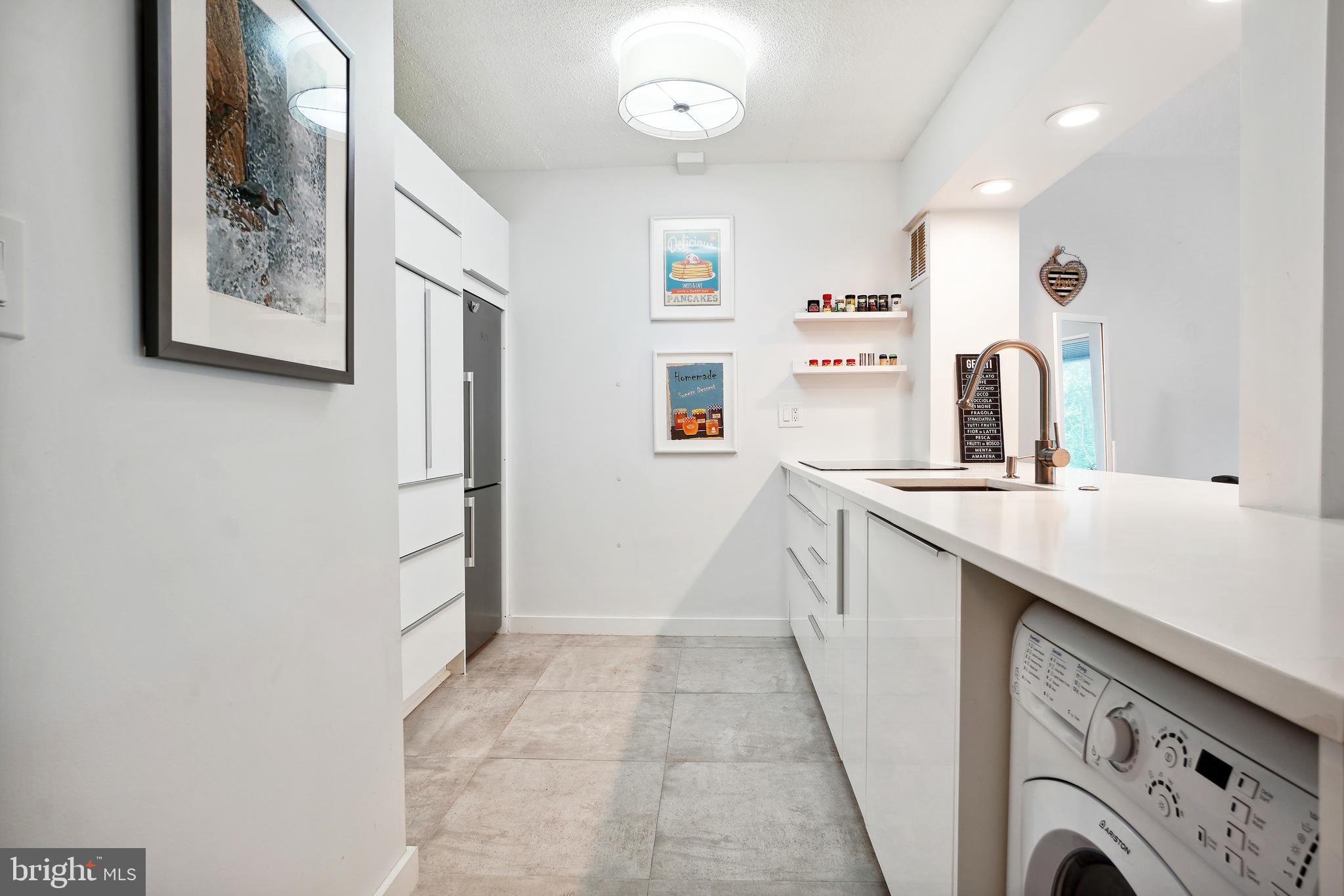 2141 Wisconsin Avenue Northwest, Unit 103 Washington, DC 20007 - Photo 6 of 30 a kitchen with a refrigerator and a sink
